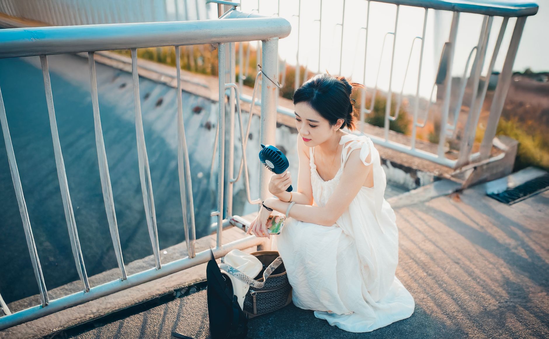 羽根を外して洗える分解タイプのハンディファンを使う女性