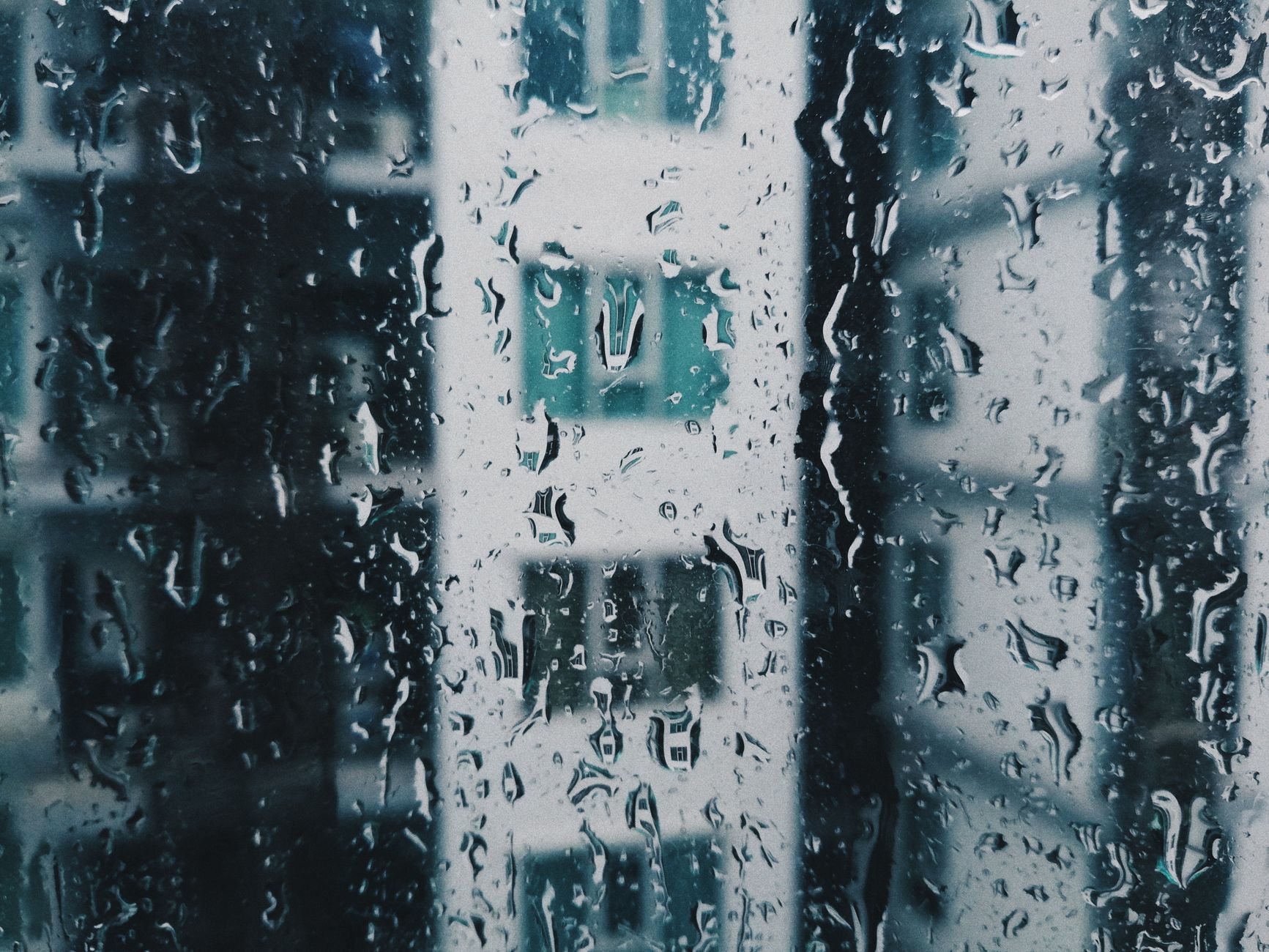 窓ガラスに付いた結露と雨の水滴。室内の湿気の多さをイメージした写真
