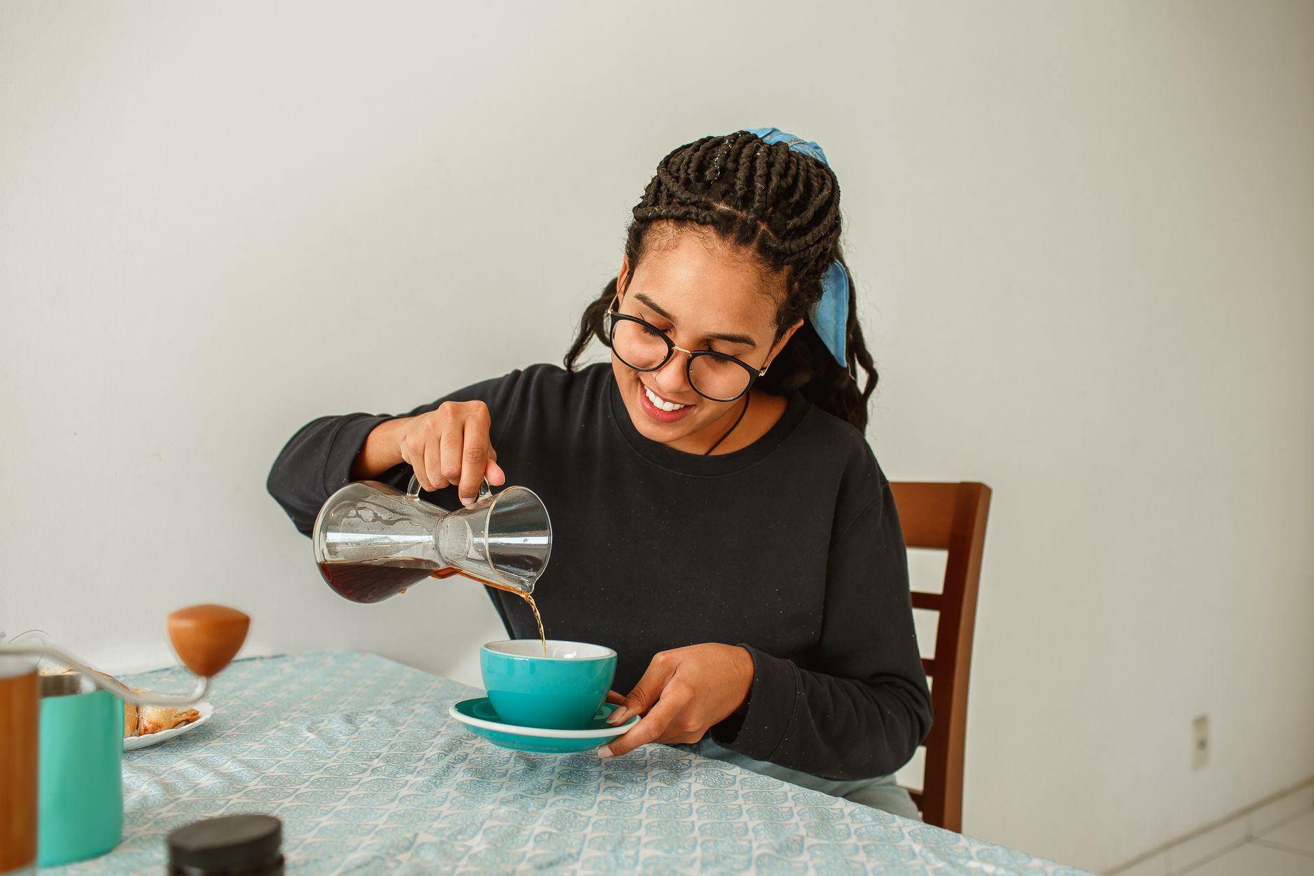 自宅のテーブルでコーヒーをカップに注ぐ様子