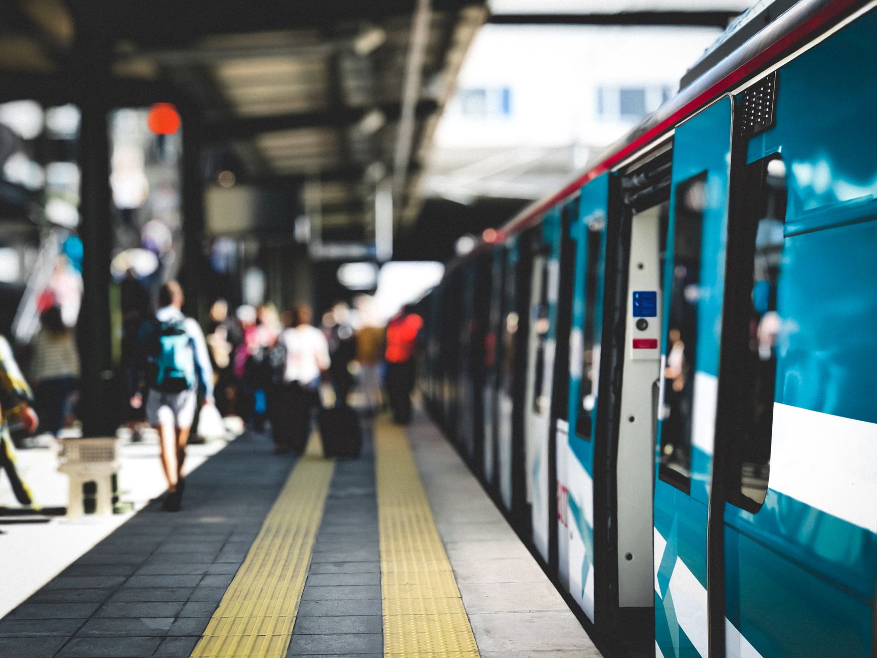 通勤時間帯の駅のホームと停車中の電車|シーンによって周囲の音の大きさが変わることを示す写真