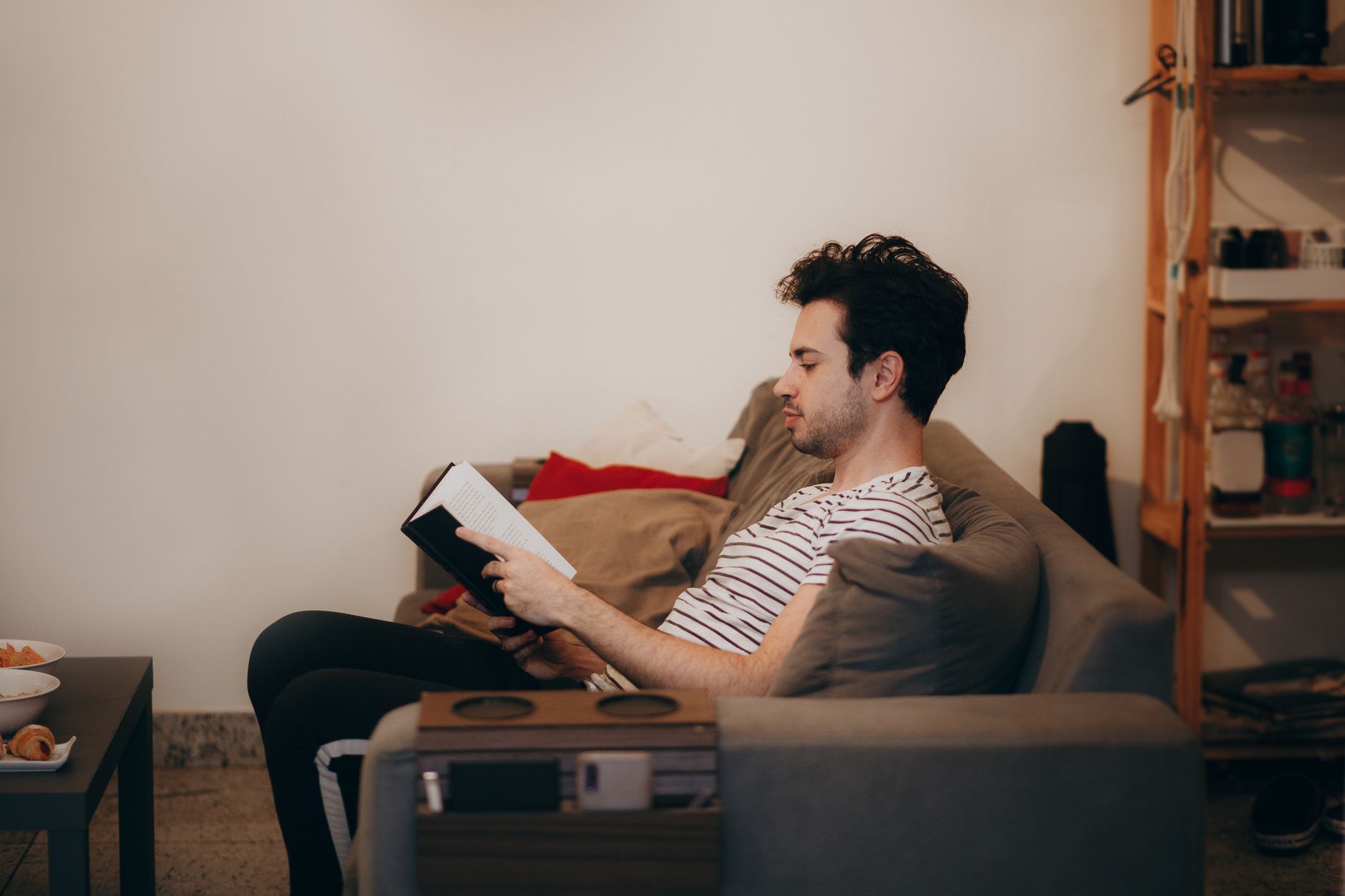 静かな部屋のソファで本を読む人