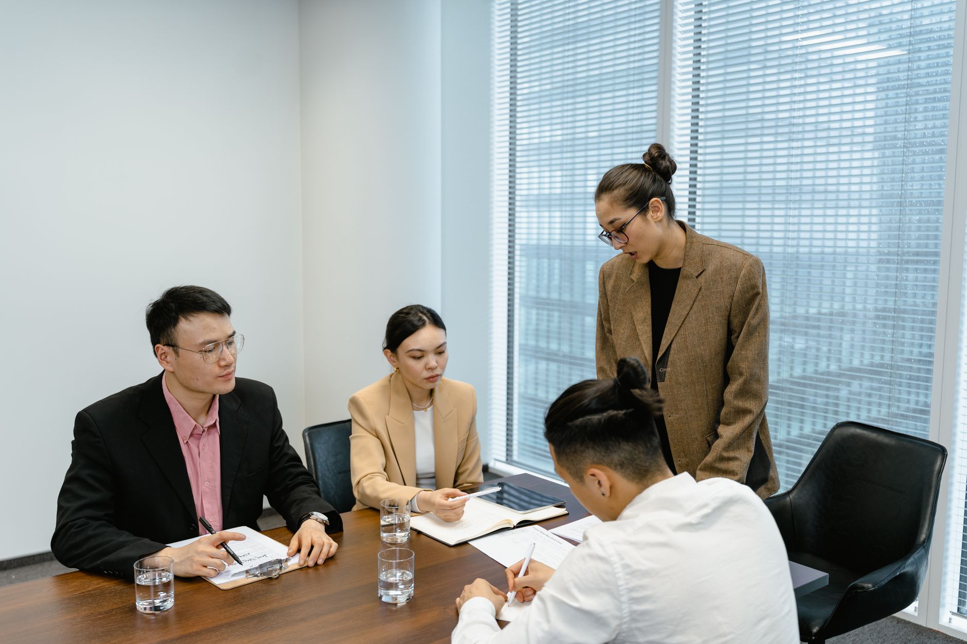 会議室で資料を見比べながら検討している人たちの写真
