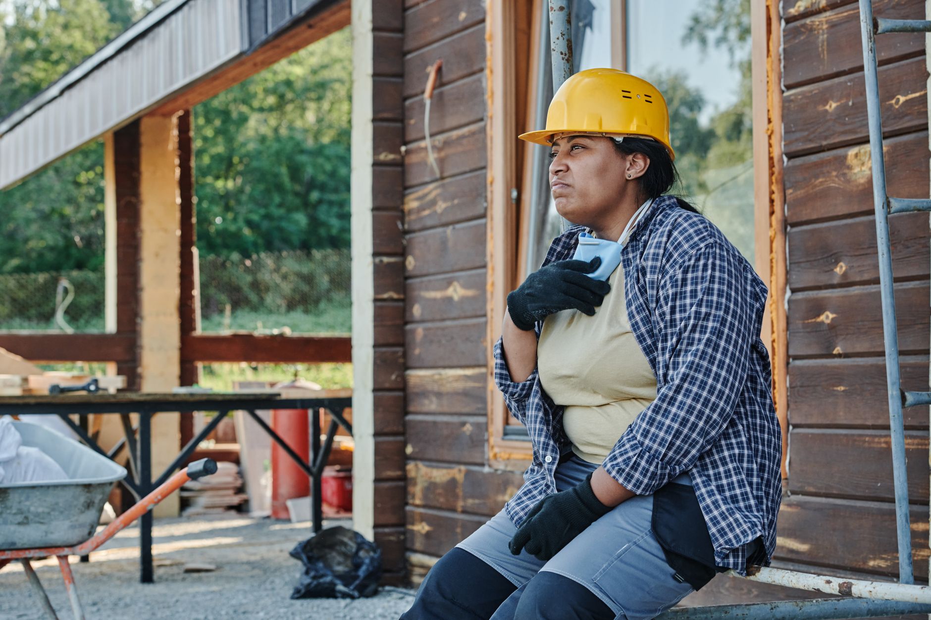 屋外作業の合間に首元を冷やす作業者(軽さと冷却力のトレードオフのイメージ)
