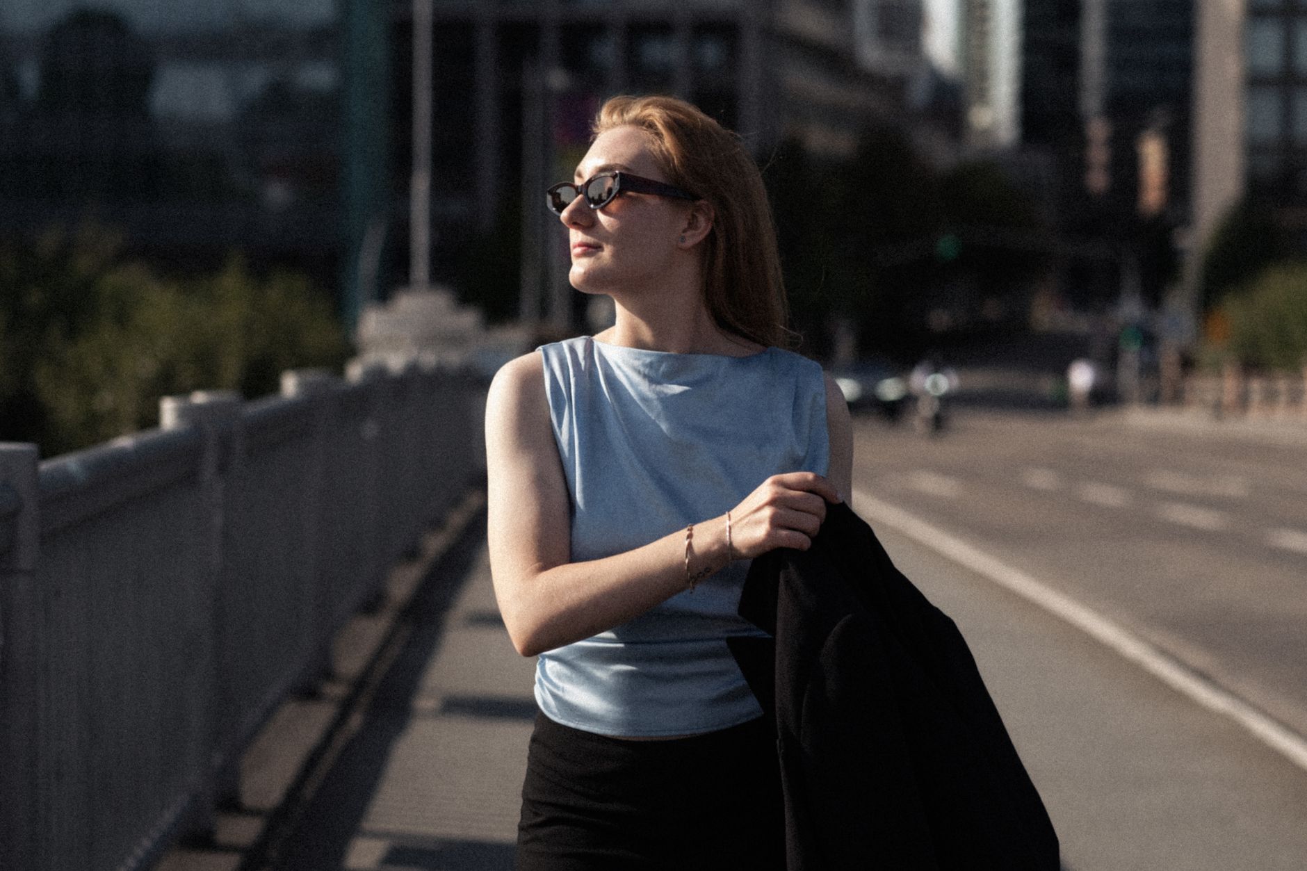 日差しの強い夏の街を歩く女性。屋外の外気温と使用時間から冷却プレート付きネッククーラーを選ぶイメージ