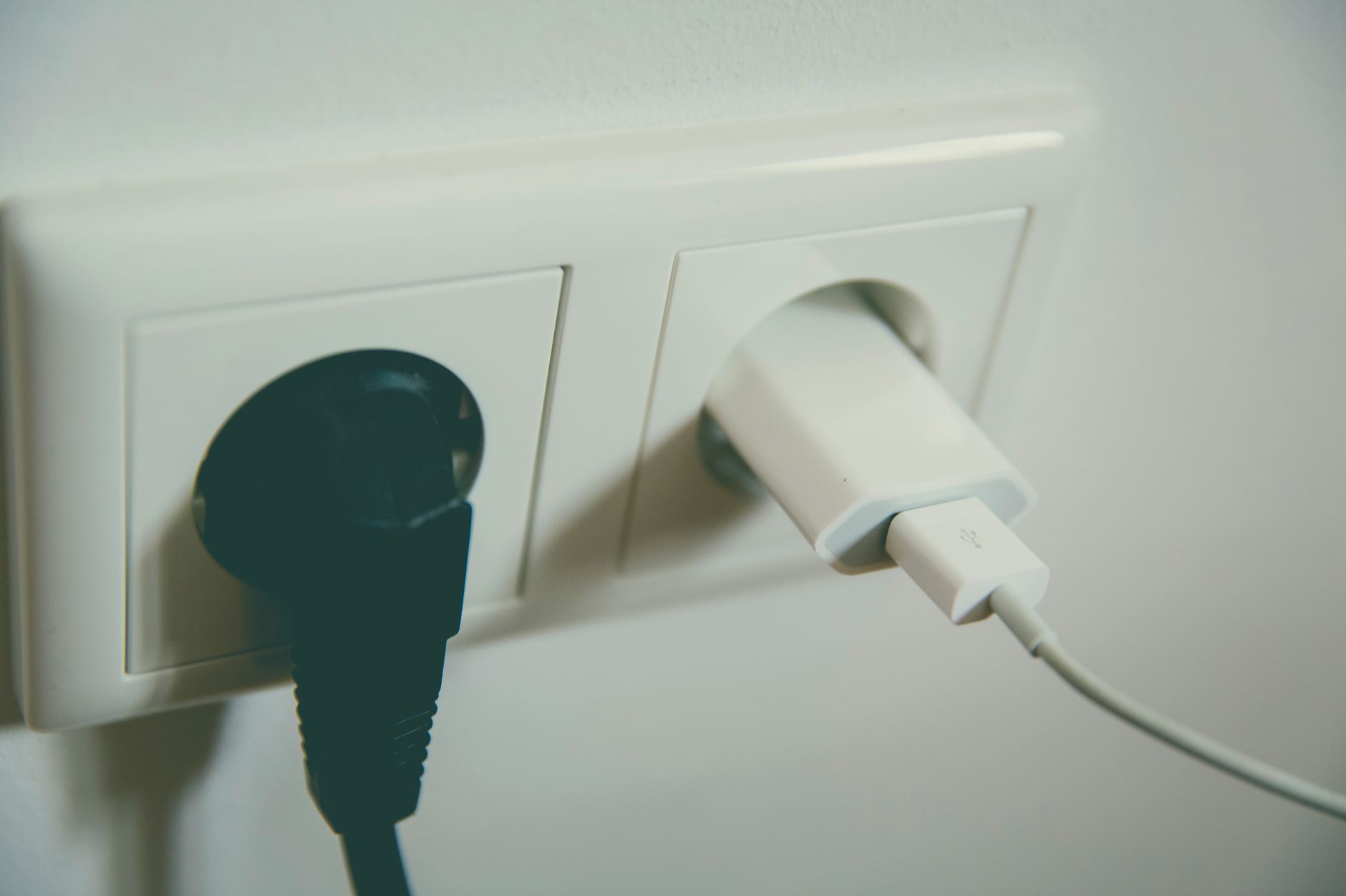 壁のコンセントに電源プラグを差し込む様子